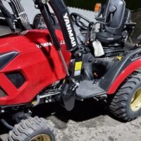 roter Traktor mit Schaufel von ST Service Stefan Trichlin