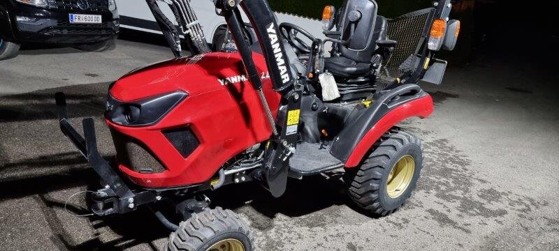 roter Traktor mit Schaufel von ST Service Stefan Trichlin